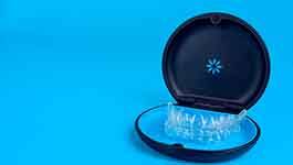 Set of aligners in Invisalign case with light blue background